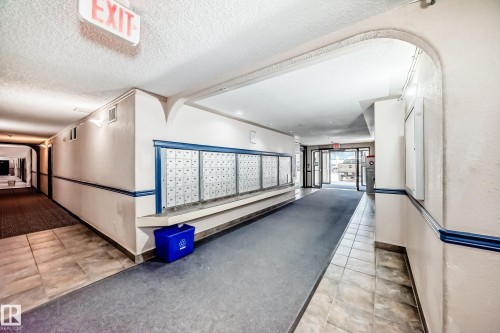 Building hallway featuring a bank of mailboxes, tiled flooring, and carpeted walkways - 126 10535 122 Street, Edmonton, AB 