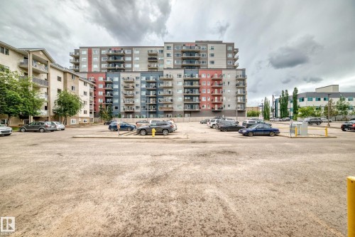Multi-story residential buildings featuring balconies and a large outdoor parking area - 126 10535 122 Street, Edmonton, AB 