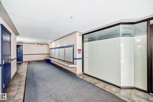 Common area featuring individual mailboxes, dark blue entry doors, and a carpeted hallway - 126 10535 122 Street, Edmonton, AB 
