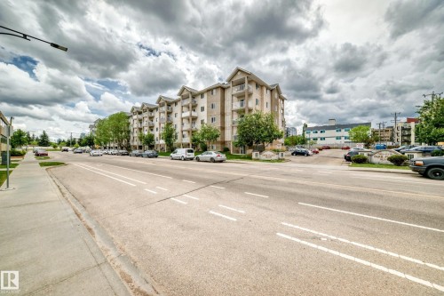 Multi-story residential building featuring light-colored exterior siding, multiple balconies, and gabled roof accents - 126 10535 122 Street, Edmonton, AB 
