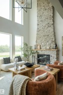 Great room featuring a floor-to-ceiling stone fireplace with an integrated linear firebox and a natural wood mantel - 