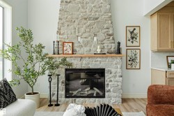Floor-to-ceiling stone fireplace featuring a wood mantel - 