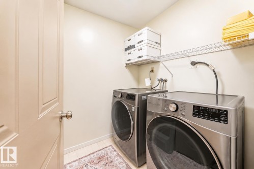 Dedicated laundry area featuring wire shelving, light-toned walls, and wood-finish flooring - 512 3 Perron Street, St. Albert, AB 