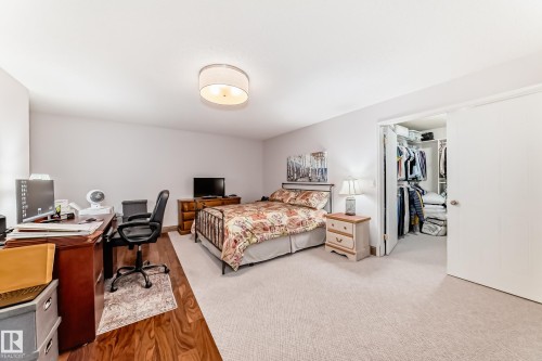 Spacious bedroom featuring light-toned carpeting and wood-finish flooring - 512 3 Perron Street, St. Albert, AB 