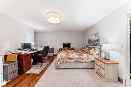 Spacious room featuring a drum light fixture, recessed lighting, and a blend of wood-finish flooring and light-colored carpeting - 512 3 Perron Street, St. Albert, AB 