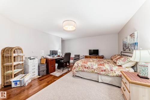 Spacious room with light neutral wall tones, wood-finish flooring, and a large area rug - 512 3 Perron Street, St. Albert, AB 