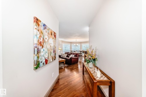 Hardwood flooring throughout the entry, leading to an open living area with large bay windows - 512 3 Perron Street, St. Albert, AB 