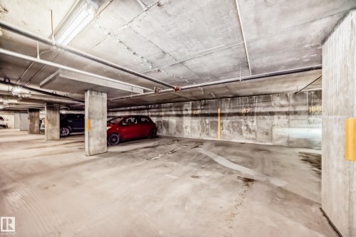 Concrete subterranean parking garage with clearly marked parking spaces and overhead fluorescent lighting - 512 3 Perron Street, St. Albert, AB 
