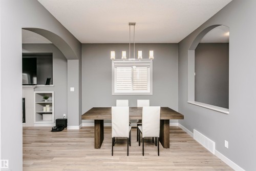 Dining area featuring light wood-finish flooring and a contemporary chandelier - 21807 97 Avenue, Edmonton, AB 