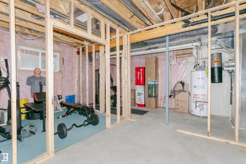 Unfinished basement space featuring visible wood framing, concrete flooring, and exposed utility infrastructure - 21807 97 Avenue, Edmonton, AB 