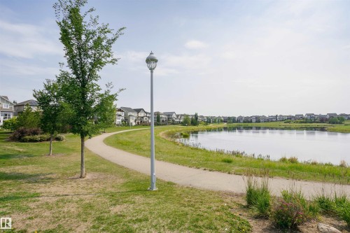 Curved paved pathway alongside a body of water with a grassy bank - 21807 97 Avenue, Edmonton, AB 
