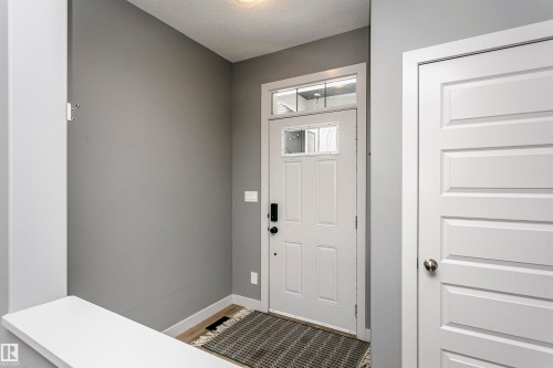 Entryway featuring a white paneled door with glass inserts and transom window, recessed lighting, and wood-finish flooring - 21807 97 Avenue, Edmonton, AB 