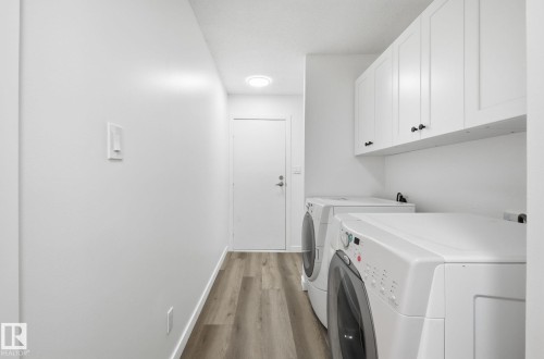 Laundry area featuring wood finished floors, cabinet space, and closets. - 2722 104A Street, Edmonton, AB 