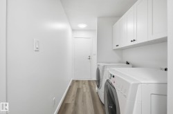 Laundry area featuring wood finished floors, cabinet space, and closets. - 