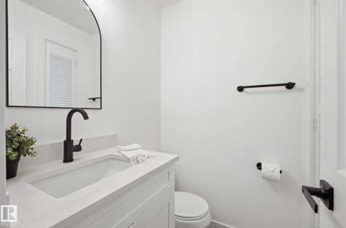 Half bathroom in main floor featuring vanity and toilet - 2722 104A Street, Edmonton, AB 
