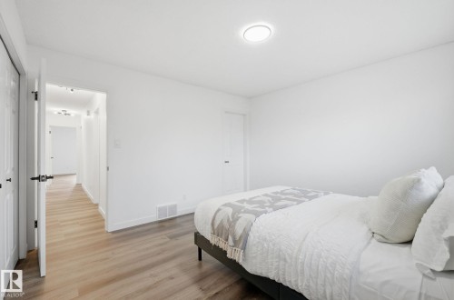 Bedroom with light wood-type flooring and two closets - 2722 104A Street, Edmonton, AB 