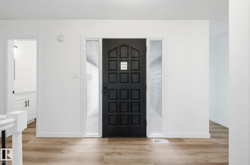 Entryway featuring light wood-style floors and a textured ceiling - 2722 104A Street, Edmonton, AB 