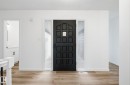 Entryway featuring light wood-style floors and a textured ceiling - 2722 104A Street, Edmonton, AB 