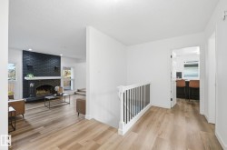 Corridor featuring light wood finished floors, a textured ceiling, and recessed lighting, with plenty of natural light. - 
