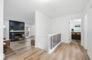 Corridor featuring light wood finished floors, a textured ceiling, and recessed lighting, with plenty of natural light. - 2722 104A Street, Edmonton, AB 