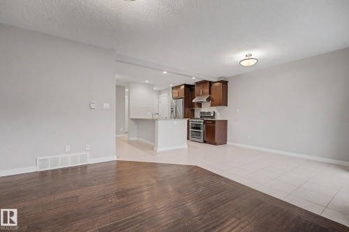Open-concept living space featuring contrasting wood-finish flooring and light-toned tile - 16810 53 Street, Edmonton, AB 