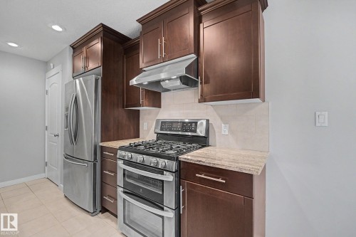 Kitchen featuring stainless steel appliances, including a double-oven range and a French door refrigerator - 16810 53 Street, Edmonton, AB 