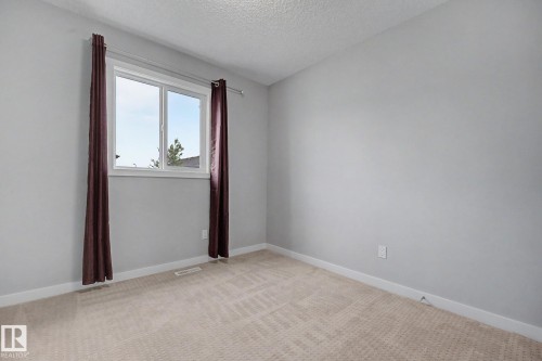 Light gray painted walls with white trim and a neutral patterned carpet - 16810 53 Street, Edmonton, AB 