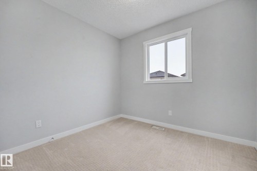 Neutral-toned carpet flooring and light gray walls create a versatile interior - 16810 53 Street, Edmonton, AB 