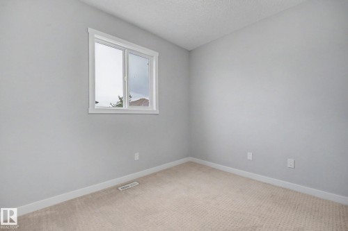 Neutral gray walls complemented by white baseboards and trim around the window - 16810 53 Street, Edmonton, AB 