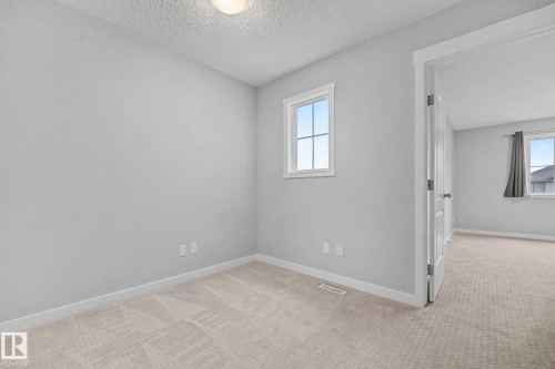 Neutral wall tones enhancing a bright interior with a window featuring white trim - 16810 53 Street, Edmonton, AB 