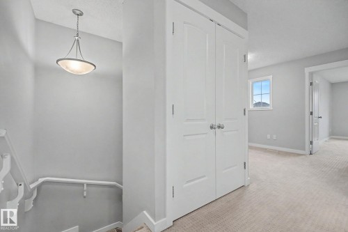 Landing area featuring light gray wall paint and textured carpeting - 16810 53 Street, Edmonton, AB 