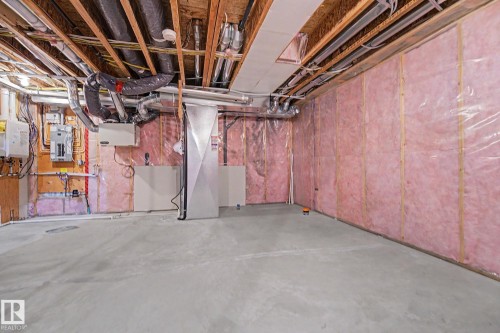 Unfinished basement featuring exposed wood joists, pink insulation, concrete flooring, and visible ductwork - 16810 53 Street, Edmonton, AB 