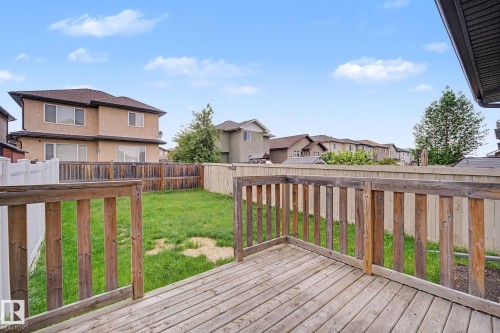 Backyard space featuring a wooden deck with railing, a grass lawn, and wood fencing - 16810 53 Street, Edmonton, AB 