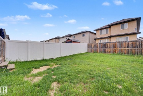 Expansive green space featuring a white privacy fence and a wood-panel fence - 16810 53 Street, Edmonton, AB 