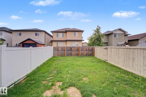 Expansive fenced yard featuring a white vinyl fence and natural wood fencing - 16810 53 Street, Edmonton, AB 