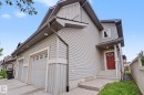 Gray siding exterior featuring a red entry door, covered porch, and concrete steps - 16810 53 Street, Edmonton, AB 
