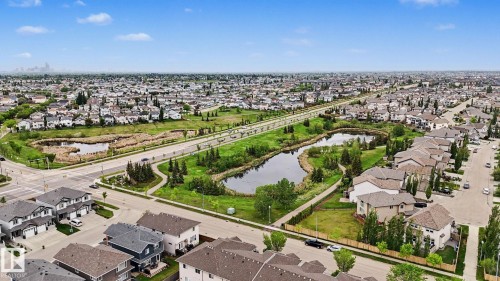 Aerial perspective showcasing a residential area with a prominent naturalized retention pond and extensive green space - 16810 53 Street, Edmonton, AB 