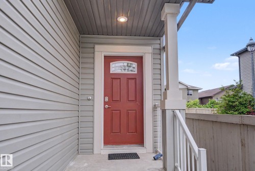 Red paneled entry door with decorative glass insert - 16810 53 Street, Edmonton, AB 