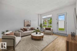 Spacious living area featuring light wood-finish flooring, a full-light exterior door, and large window - 