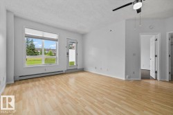 Spacious interior with wood-finish flooring, a large window, and an exterior door providing direct outdoor access - 