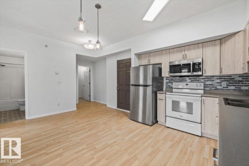 Open-concept living space featuring wood-finish flooring throughout - 116 6315 135 Avenue, Edmonton, AB 