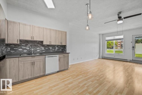 Open-concept living area featuring light wood-finish flooring throughout - 116 6315 135 Avenue, Edmonton, AB 