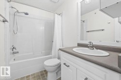 Bathroom featuring a white vanity with a gray countertop, an undermount sink, and a mirrored medicine cabinet - 