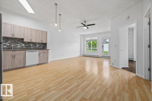 Open-concept living area featuring wood-finish flooring throughout - 116 6315 135 Avenue, Edmonton, AB 