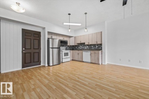 Open-concept living space featuring wood-finish flooring throughout - 116 6315 135 Avenue, Edmonton, AB 