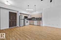 Open-concept living space featuring wood-finish flooring throughout - 
