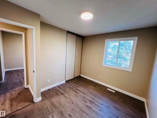 Interior room featuring wood-finish flooring, neutral wall tones, and white trim - 2544 79 Street, Edmonton, AB - Indoor Photo Showing Other Room