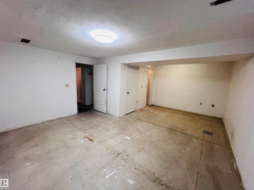 Unfinished interior space with exposed concrete subfloor, white painted walls, and overhead lighting - 2544 79 Street, Edmonton, AB - Indoor