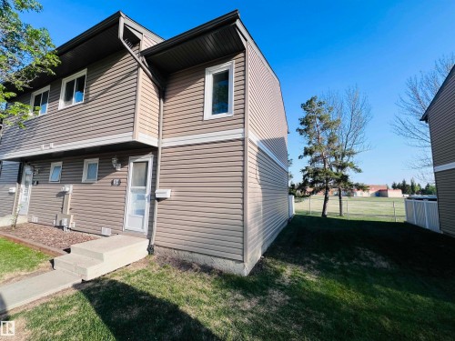 Multi-level townhouse exterior featuring horizontal siding in a neutral tone with white trim accents - 2544 79 Street, Edmonton, AB - Outdoor