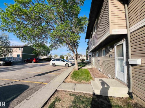 Two-story residence featuring horizontal siding, a white storm door, and an exterior wall light - 2544 79 Street, Edmonton, AB - Outdoor